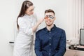 Ophthalmologist woman doctor checks diagnose eyesight myopia, hyperopia young man. Royalty Free Stock Photo