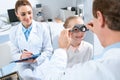 ophthalmologists examining kid eyes with trial frame