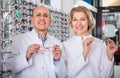 Ophthalmologists standing near display with spectacles