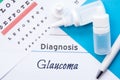 Ophthalmology diagnosis Glaucoma. Snellen eye chart, two bottles of eye drops medications lying on notebook with inscription