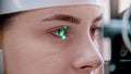 Ophthalmology treatment - a young woman checking her visual acuity - checking a reaction on the green light Royalty Free Stock Photo