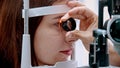 Ophthalmology treatment - a young woman checking her visual acuity with a light of special big optometry machine and