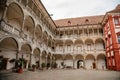 Opocno castle, renaissance chateau, courtyard with arcades and red facade, palm trees and plants in ceramic pots, columns, sunny