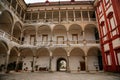 Opocno castle, renaissance chateau, courtyard with arcades and red facade, palm trees and plants in ceramic pots, columns, sunny