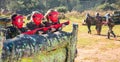 Opposing teams of happy kids shooting paintball