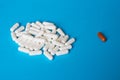 Opposition. White and brown pill capsules on a blue background