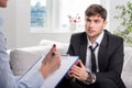 Oppressed man talking with psychologist Royalty Free Stock Photo