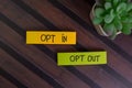 Opt In and Opt Out write on sticky notes isolated on Wooden Table