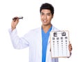 Optical doctor holding with eyechart and glassesa