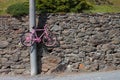 Optical effect for an hanging pink bike that seems run over a stone street, for cycling lovers