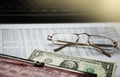 Optical glasses and dollar bill put on graph financial report. Business concept. Royalty Free Stock Photo