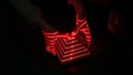 Optical illusion with red lasers, woman hand and geometric pyramid figure