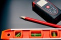 Optical level, laser range finder and a pencil lying on the floor Royalty Free Stock Photo