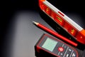Optical level, laser range finder and a pencil lying on the floor Royalty Free Stock Photo