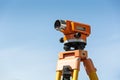 Optical level on tripod over blue sky Royalty Free Stock Photo