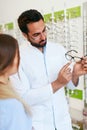 Optical Store. Eye Doctor Helping Woman Choosing Eyeglasses Royalty Free Stock Photo