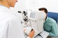 Optician with autorefractor and patient at clinic Royalty Free Stock Photo