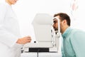 Optician with autorefractor and patient at clinic