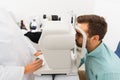 Optician with autorefractor and patient at clinic