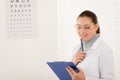 Optician doctor woman with glasses and eye chart