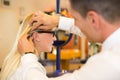 Optician examining correct fit of eyeglass frame for customer