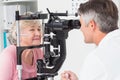 Optician examining senior female patient through slit lamp Royalty Free Stock Photo