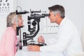 Optician examining senior patient through slit lamp Royalty Free Stock Photo