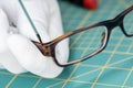 Optician hands repairing eyeglasses with a tool