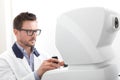 optician with keratometer, optometrist doctor examines eyesight, isolated on white Royalty Free Stock Photo