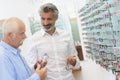 Optician and man choosing new pair glasses Royalty Free Stock Photo