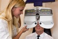 Optician or optometrist and patient with a phoropter