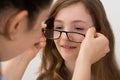 Optician Putting Eyeglasses On A Patient