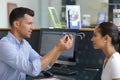 Optician putting testing glasses on to patient