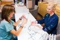 Optician salon saleswoman with her client choosing eyeglasses