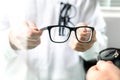Optician showing new glasses to customer for trying. Royalty Free Stock Photo