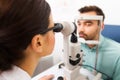 Optician with slit lamp and patient at eye clinic