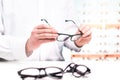 Optician in store holding glasses. Eye doctor with lenses. Royalty Free Stock Photo