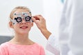 Optician with trial frame and girl at clinic Royalty Free Stock Photo