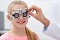 Optician with trial frame and girl at clinic Royalty Free Stock Photo