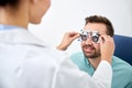 Optician with trial frame and patient at clinic