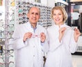Opticians helping to choose glasses in modern optics store