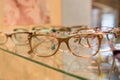 Optics, health care and vision concept - close up of eyeglasses at optician.exhibitor of glasses consisting of shelves