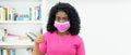 Optimistic african american woman with pink face mask