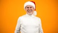 Optimistic aged man in Santa Claus hat smiling on camera, new year celebration Royalty Free Stock Photo