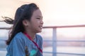 Optimistic female kid is looking out to the sea with sunset and smile. for Happiness and possitive life style concept Royalty Free Stock Photo