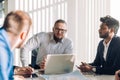 Optimistic businessman in white shirt collaborating with his team at meeting Royalty Free Stock Photo