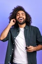 Optimistic curly arabic guy happily listen to music via headphones