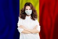 Optimistic doctor in face mask against national flag Romania. Flu epidemic and virus protection concept