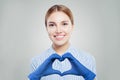 Optimistic doctor woman in protective mask making heart. Healthcare, medicine and treatment concept