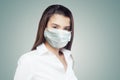 Optimistic doctor woman in protective mask on white background